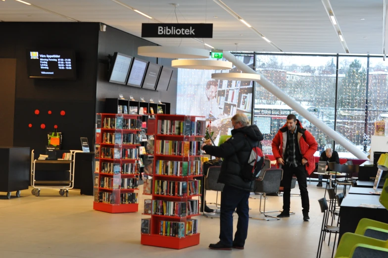 a man standing in front of a book shop filled with books