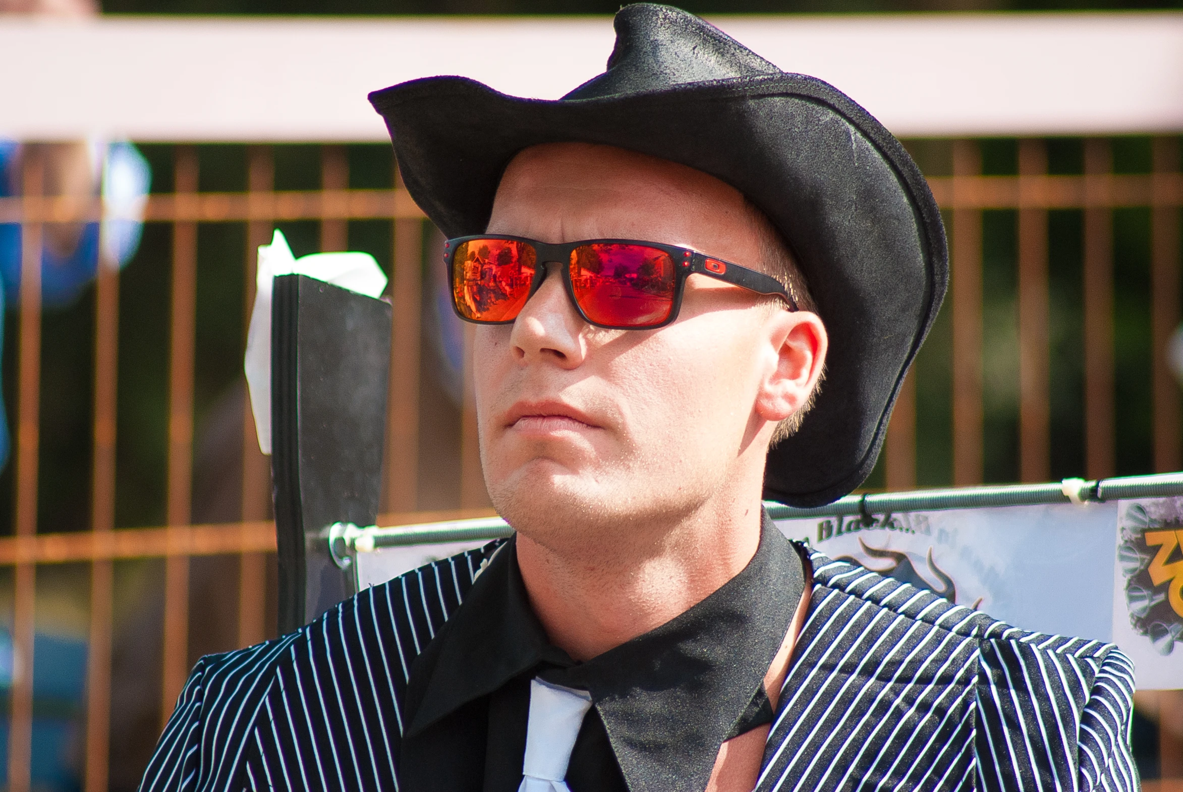 a man wearing a black and white  shirt has a hat and glasses