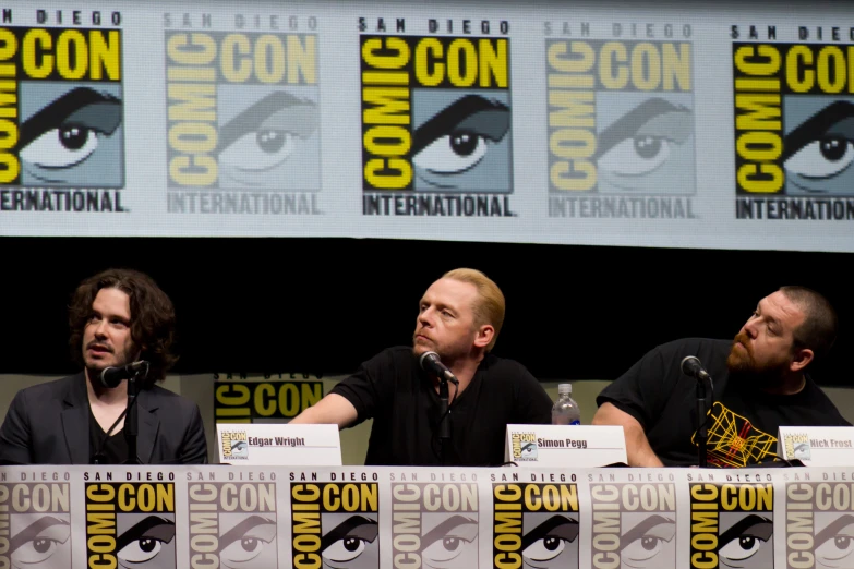 actors talking on stage during a convention at comic con