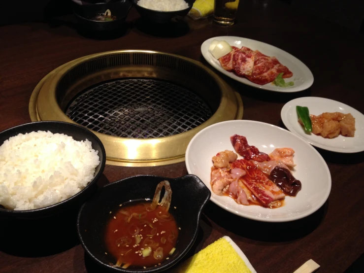 many dishes and trays sit on the table with food in it