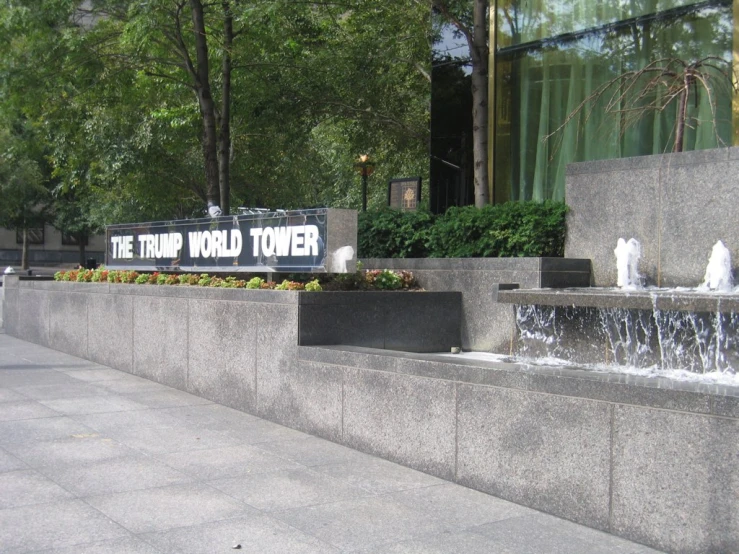 the trump world tower sign is near a fountain