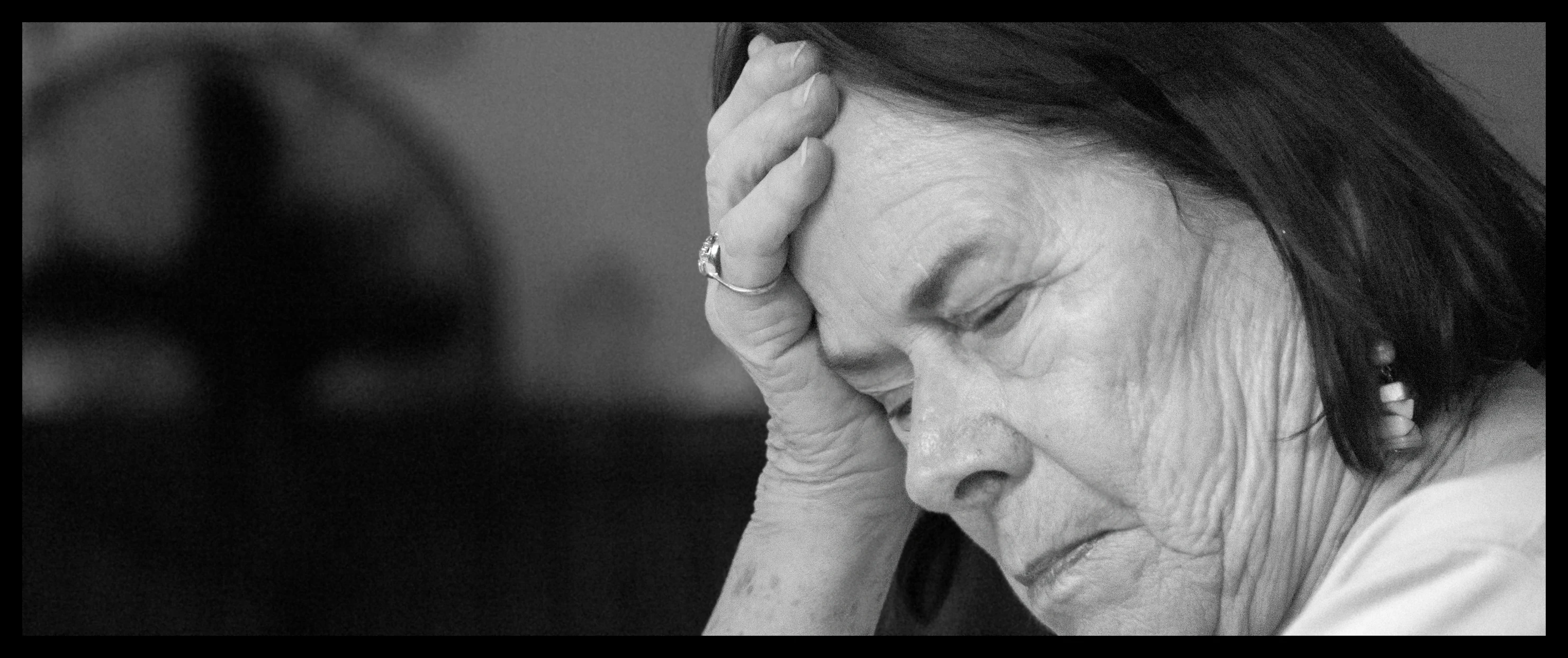 an older woman holding her head to her hair