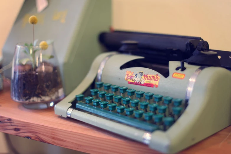 a close up of an old fashioned typewriter and a glass with tea