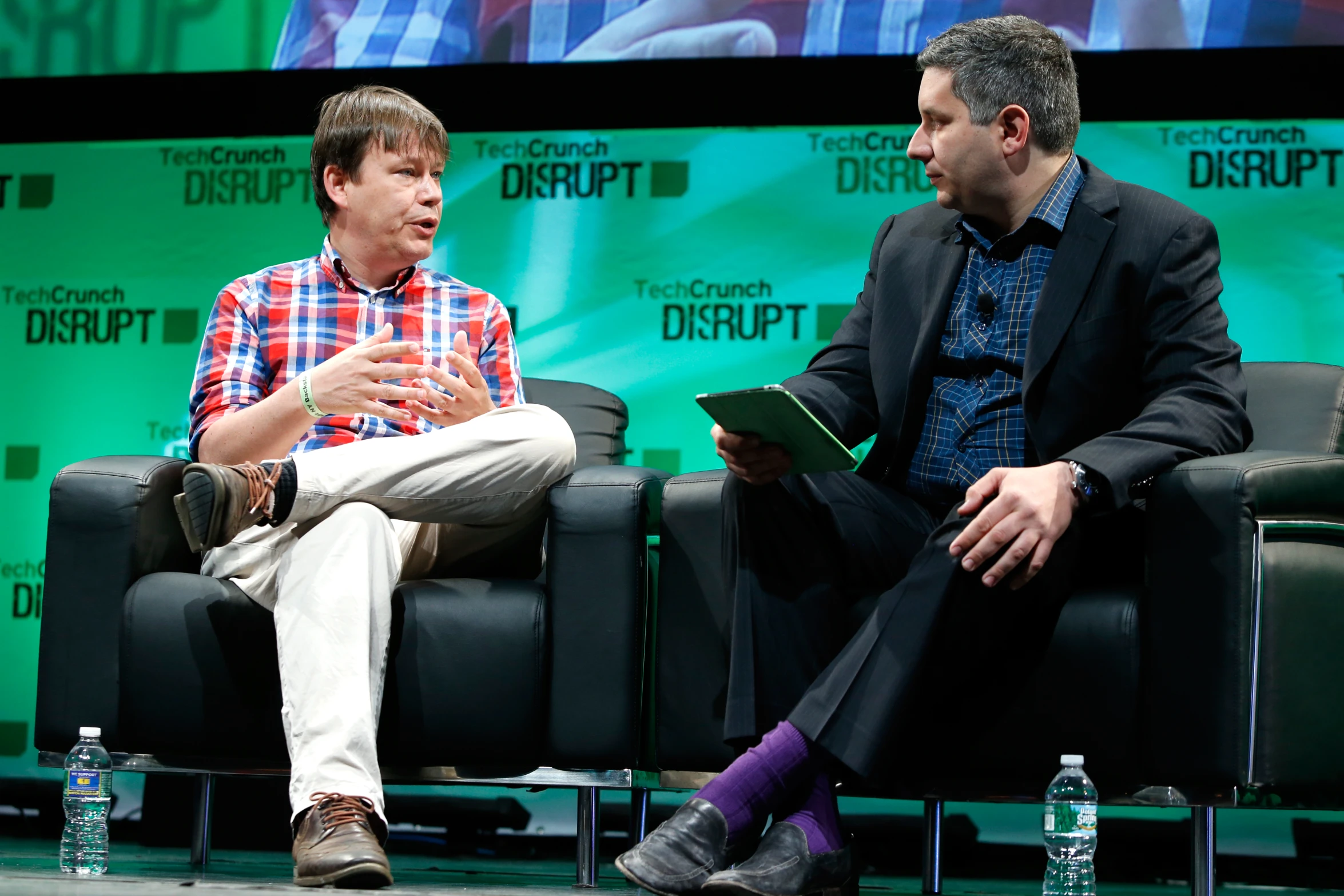 two men in conversation on stage at a tech summit