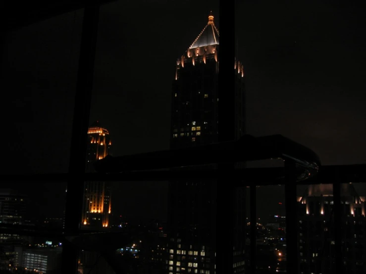 a view from a window at night overlooking a city with skyscrs