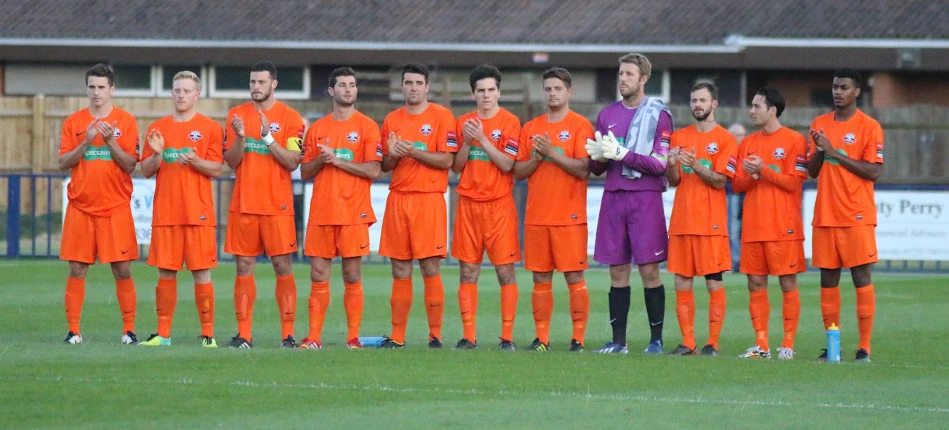 soccer players in orange uniform are posing for a group po