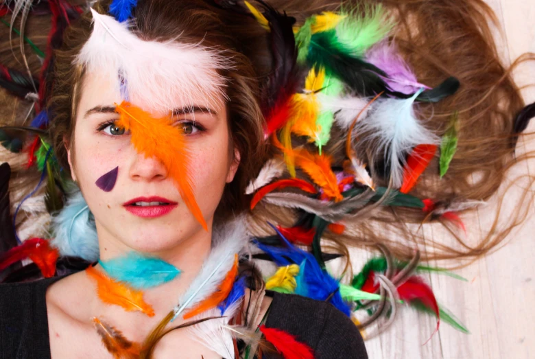 woman with multicolored feathers and crazy looking eyebrows