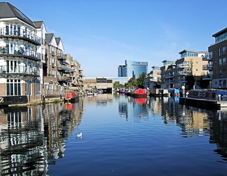 a river with boats floating on it and buildings reflected in the water