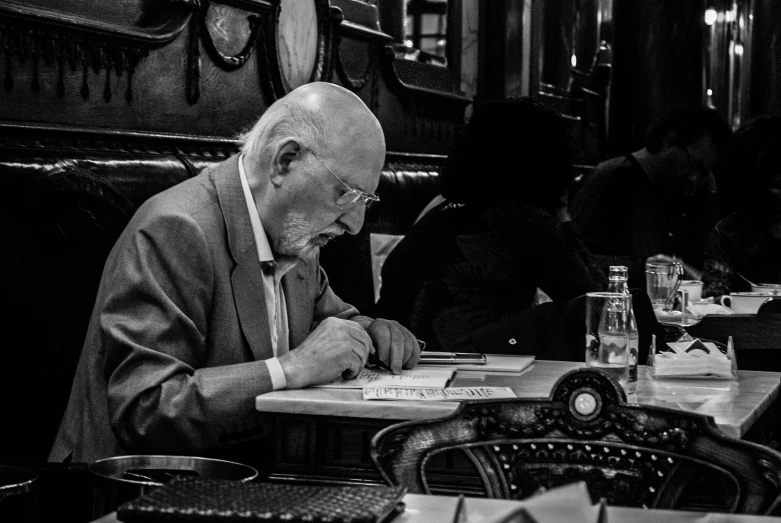 a priest is at a table in black and white