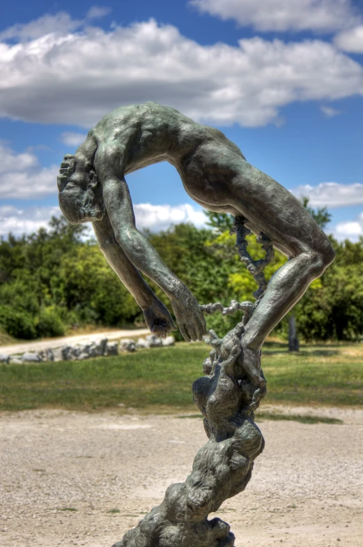 a sculpture of a man's arms and feet hanging down on another