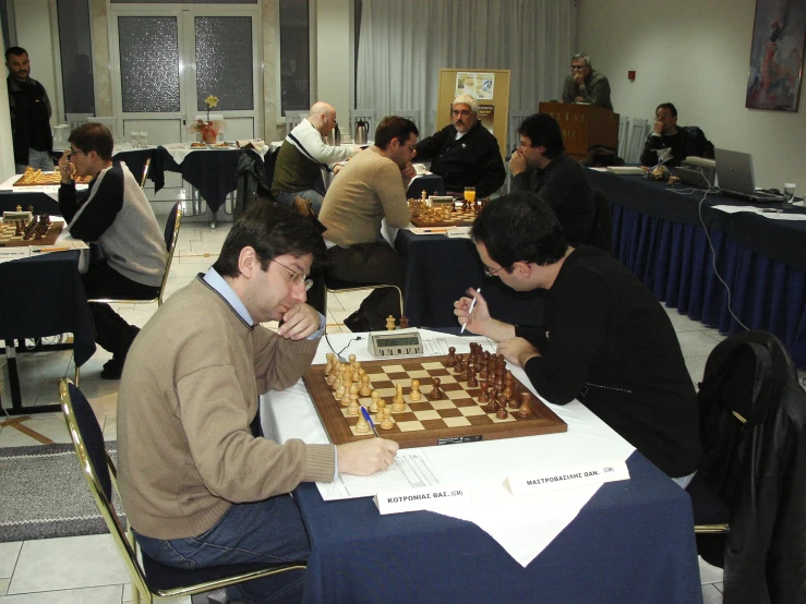 men sitting at a table playing chess