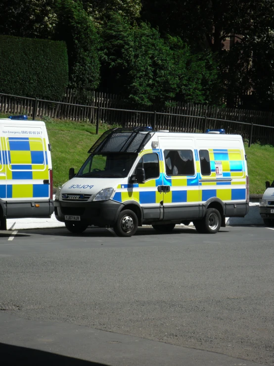 three vans are parked on the side of the road