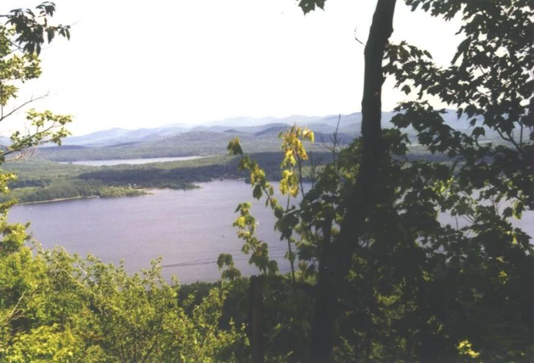 a lake sits above some trees and some hills