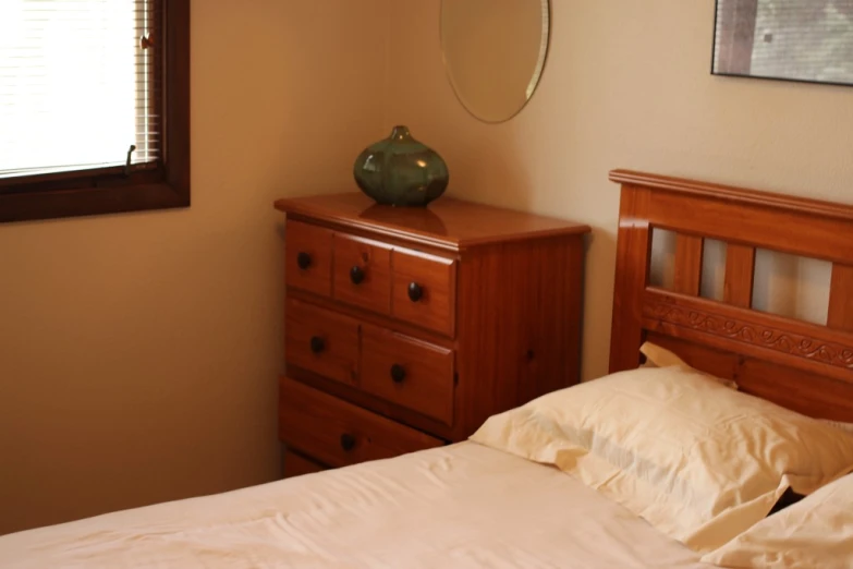 a bed in a bedroom with two lamps and dresser