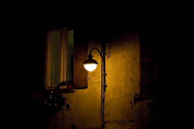 the lamp post stands next to the window on an old - fashioned building