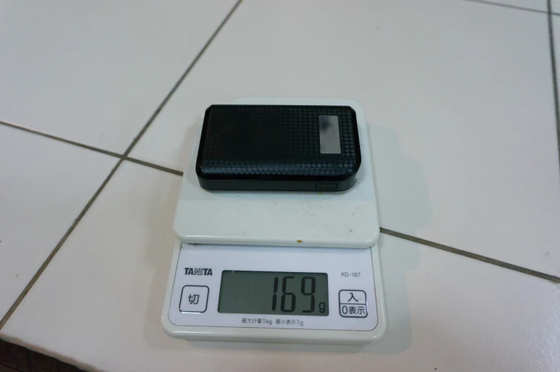 an electronic scale sitting on top of a tiled floor