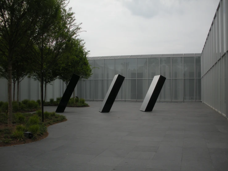 a large set of three large black sculpture sitting in a parking lot