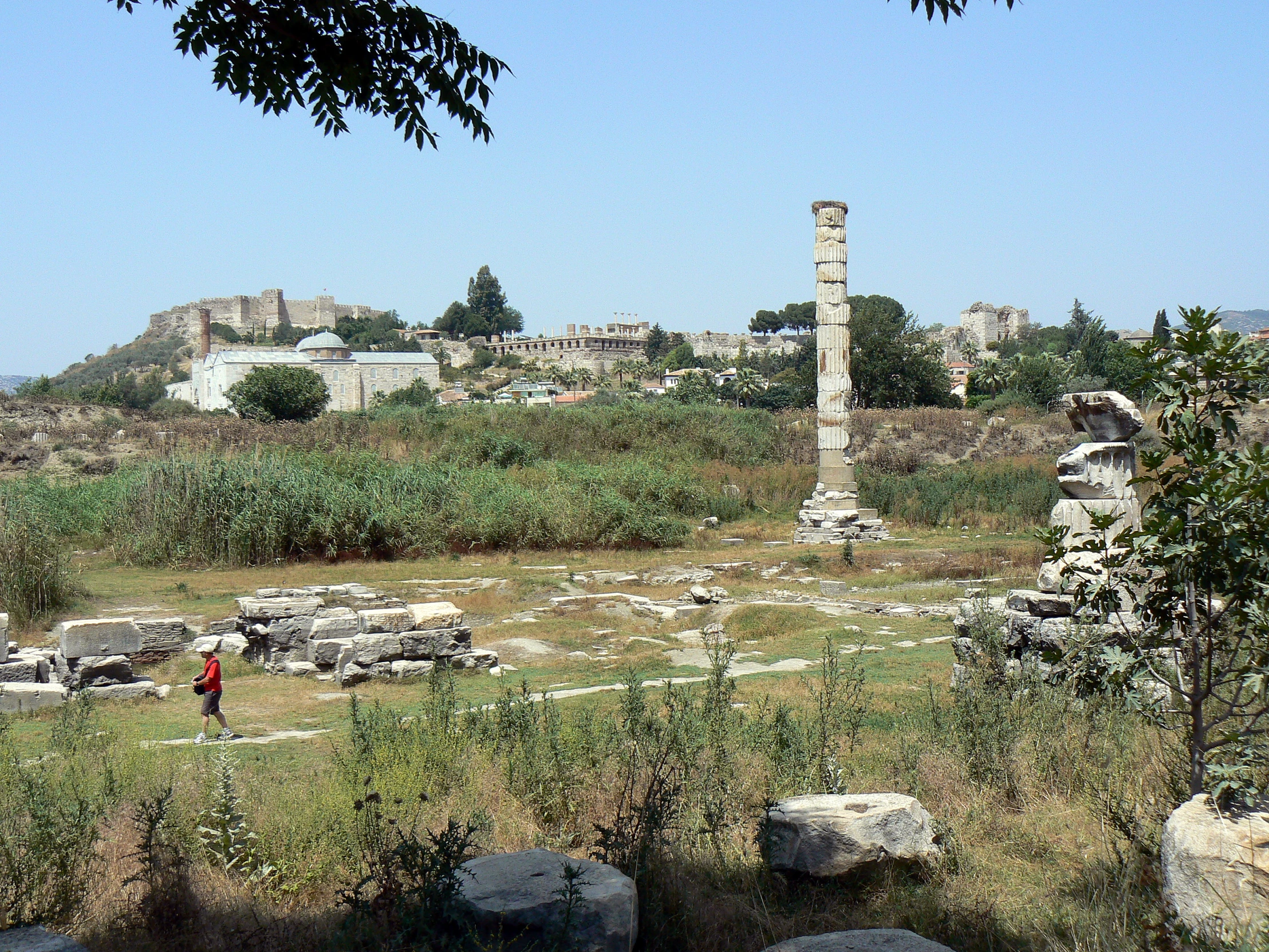 an ancient greek ruins with a child standing among them