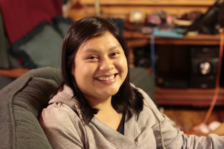 a girl smiling with her hand on a nintendo wii game controller