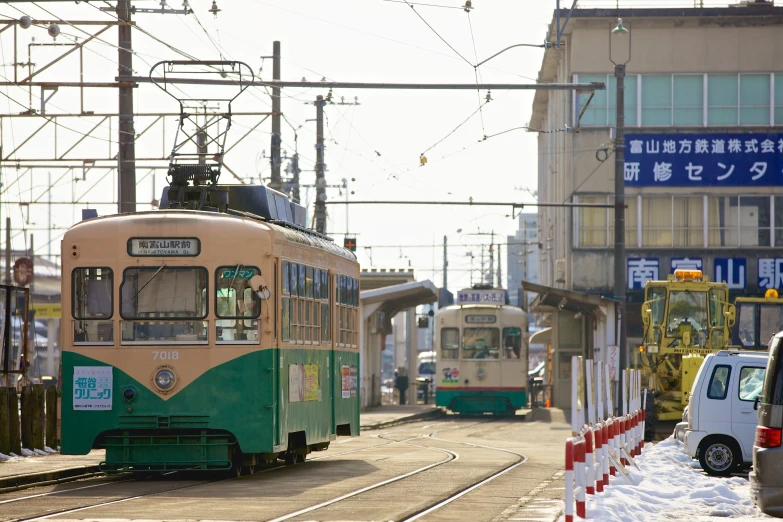 a green trolley drives through an asian town