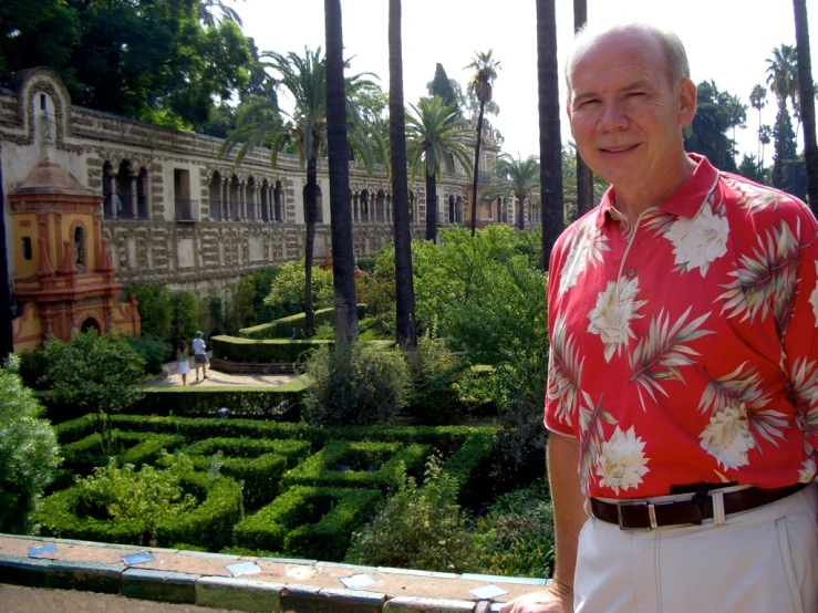 a man in red shirt standing next to a garden