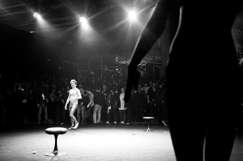 a woman walks across the runway in front of a crowd