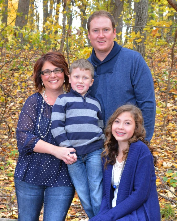 two people and a child are standing by a fallen tree