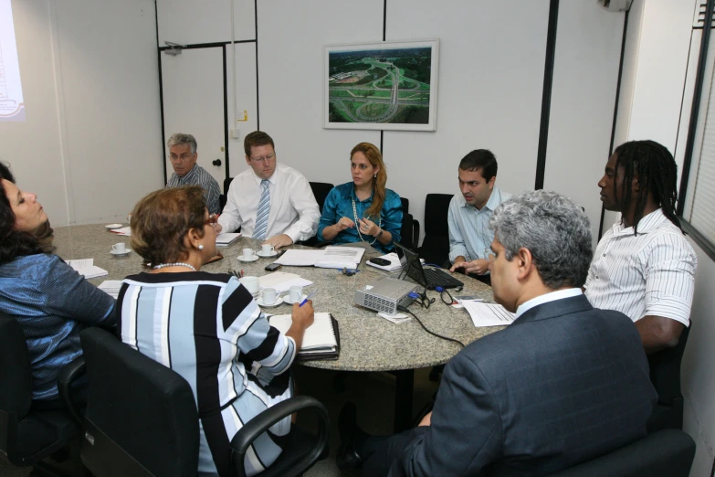 people sitting around a table talking on phone