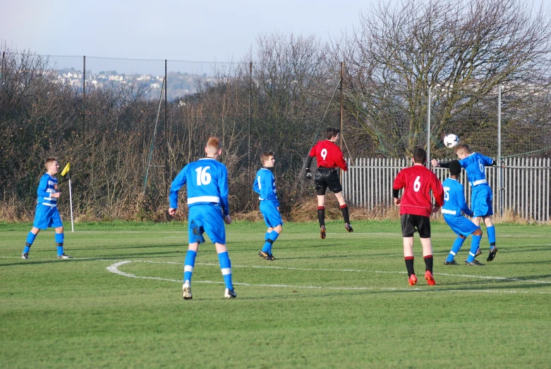 some boys are playing soccer on the field