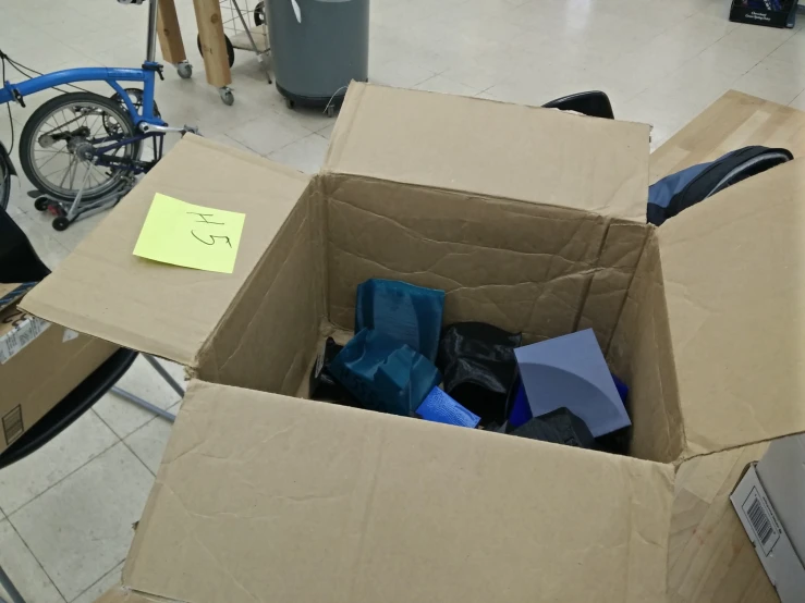 a cardboard box filled with assorted items in a garage