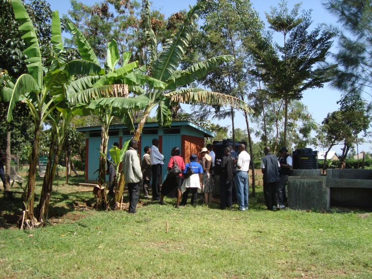 a group of people gathered around an outside fruit stand