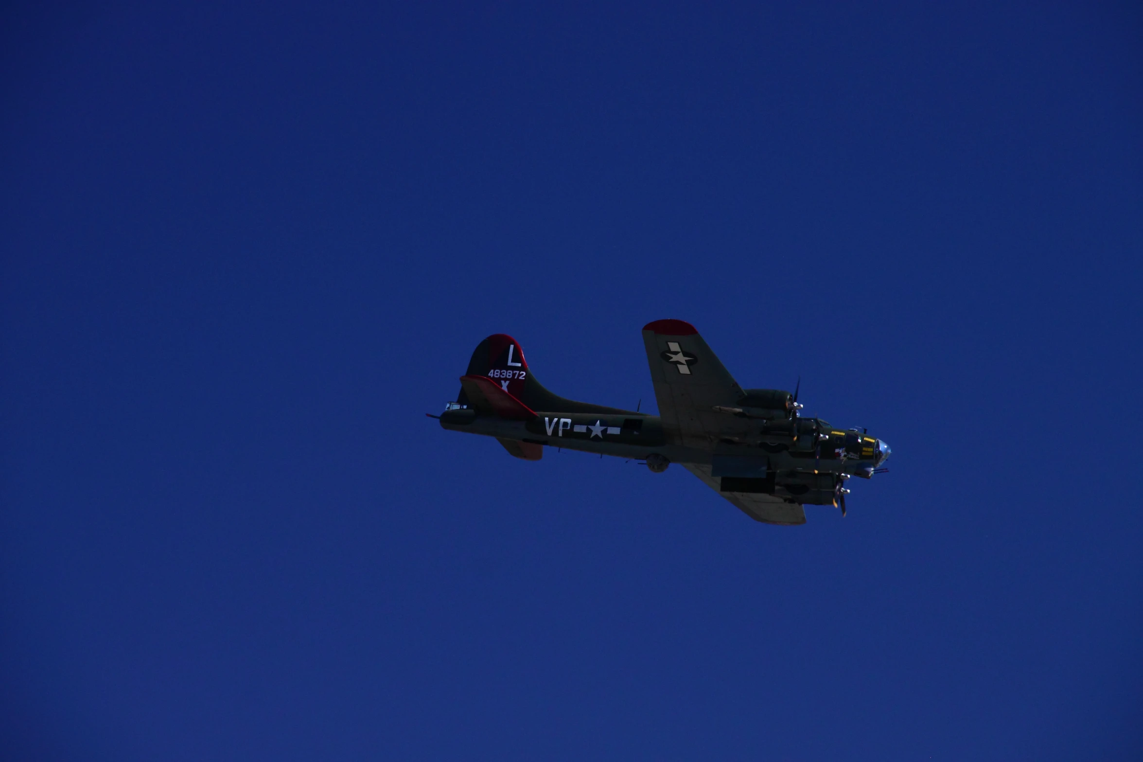 an old time plane flying in the blue sky