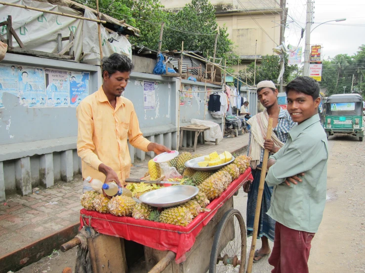 a couple of men are selling pineapples