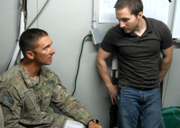 a soldier and a man sitting in a room