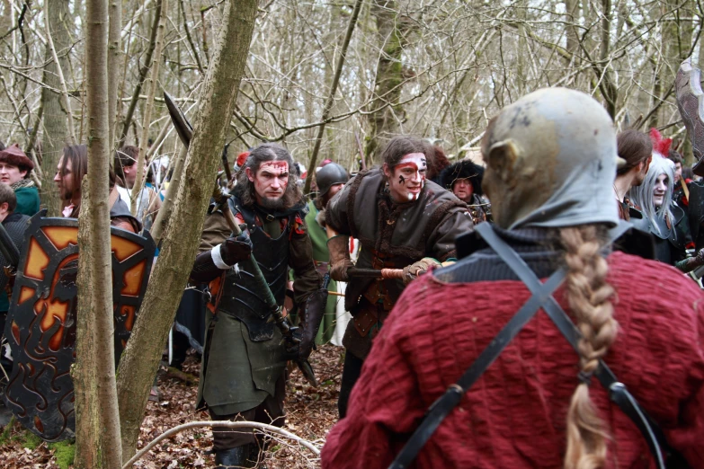 people dressed in renaissance clothing, surrounded by a forest