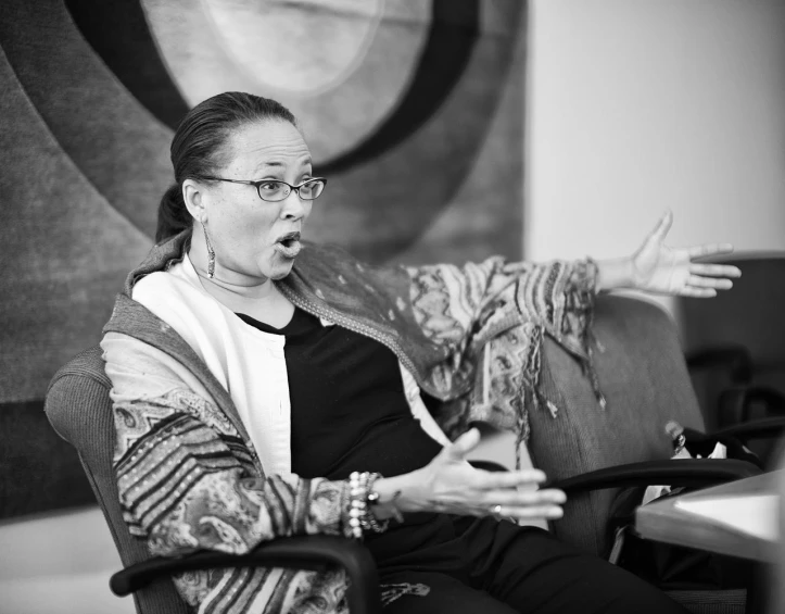 a woman sitting on a couch with her arms spread