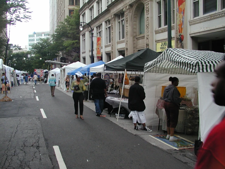 a street scene with tents and people walking