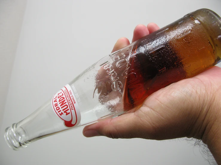 a close up of a person holding a beer