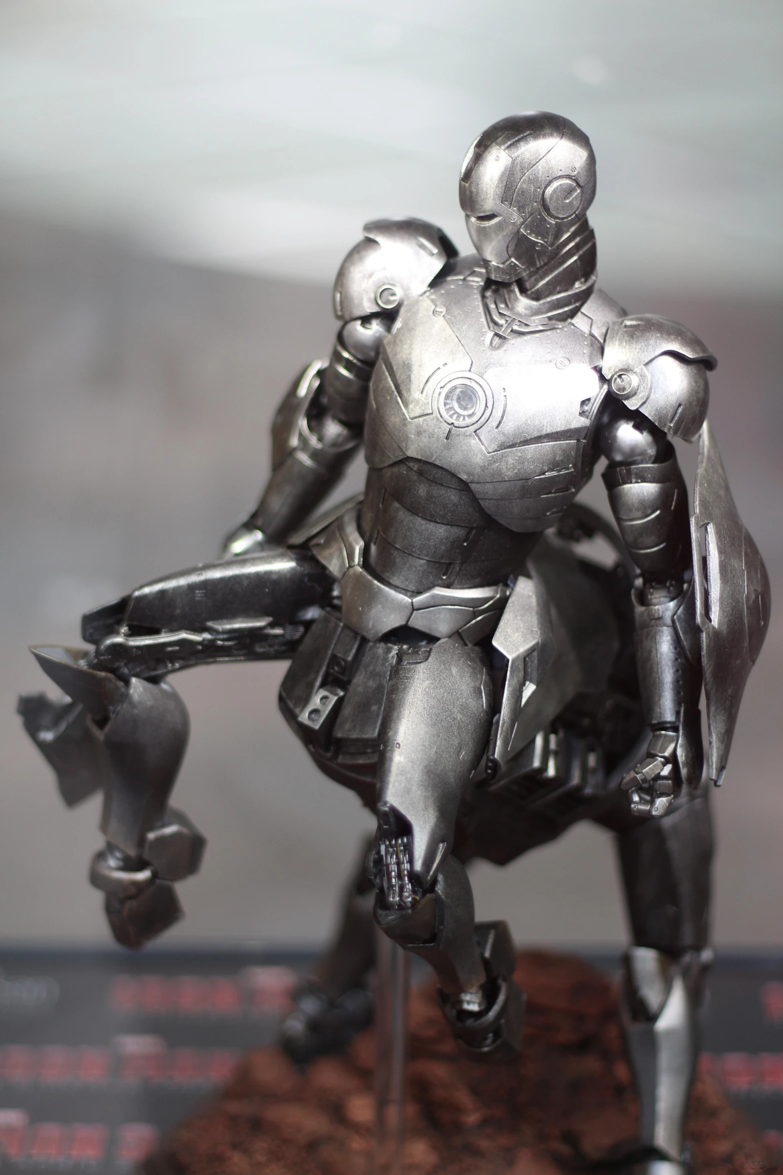 a futuristic figurine with a mechanical arm holding a helmet and shield