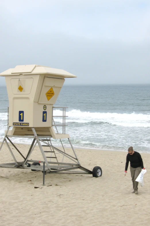 man with surf board at beach near lifeguard chair