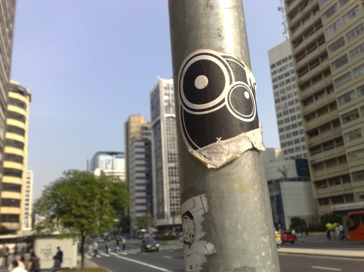a sticker is hanging on a silver pole on the street