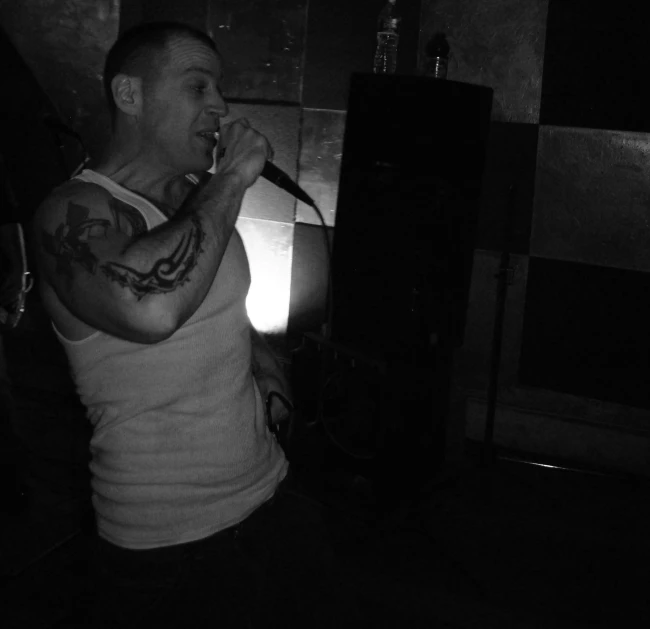 a man singing into a microphone inside a dimly lit room