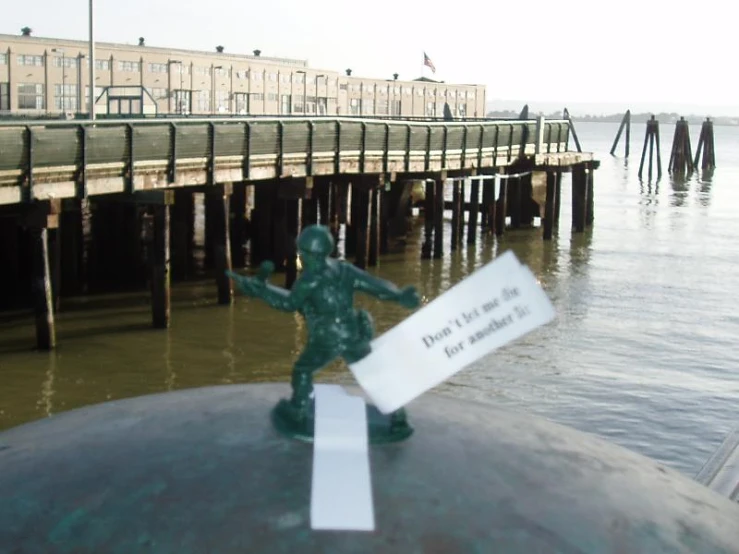 toy soldier statue posed at top of post near dock