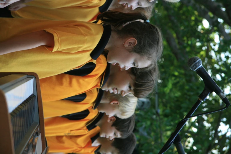 young children playing the piano in school uniforms