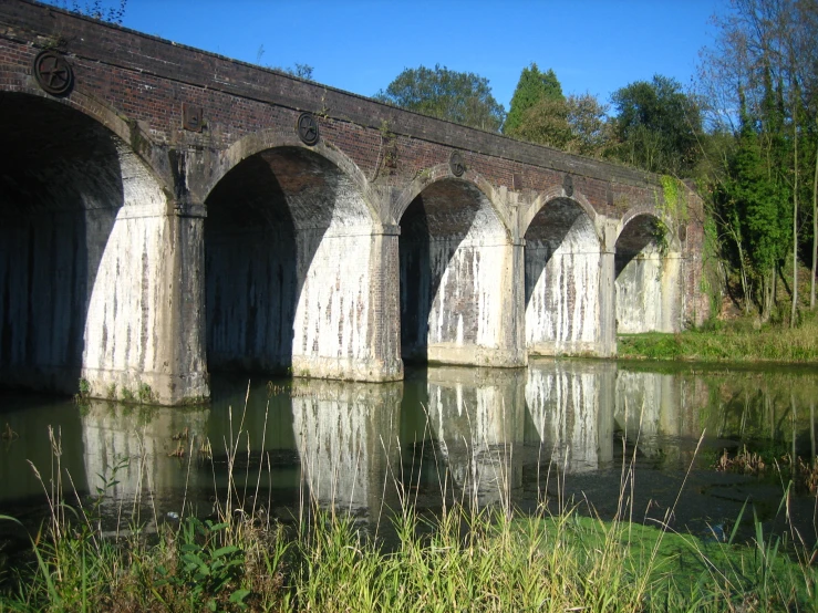 a very old stone bridge with some water underneath