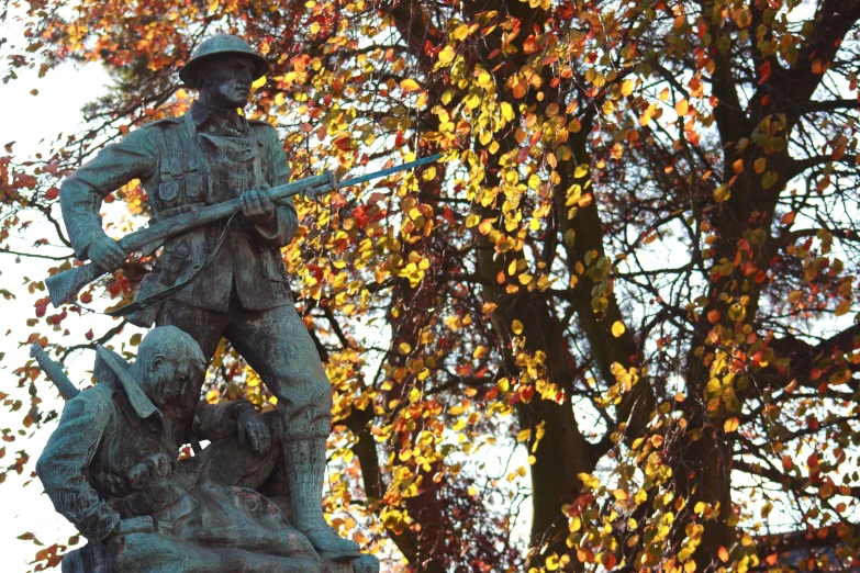 a statue standing in the middle of an autumn park