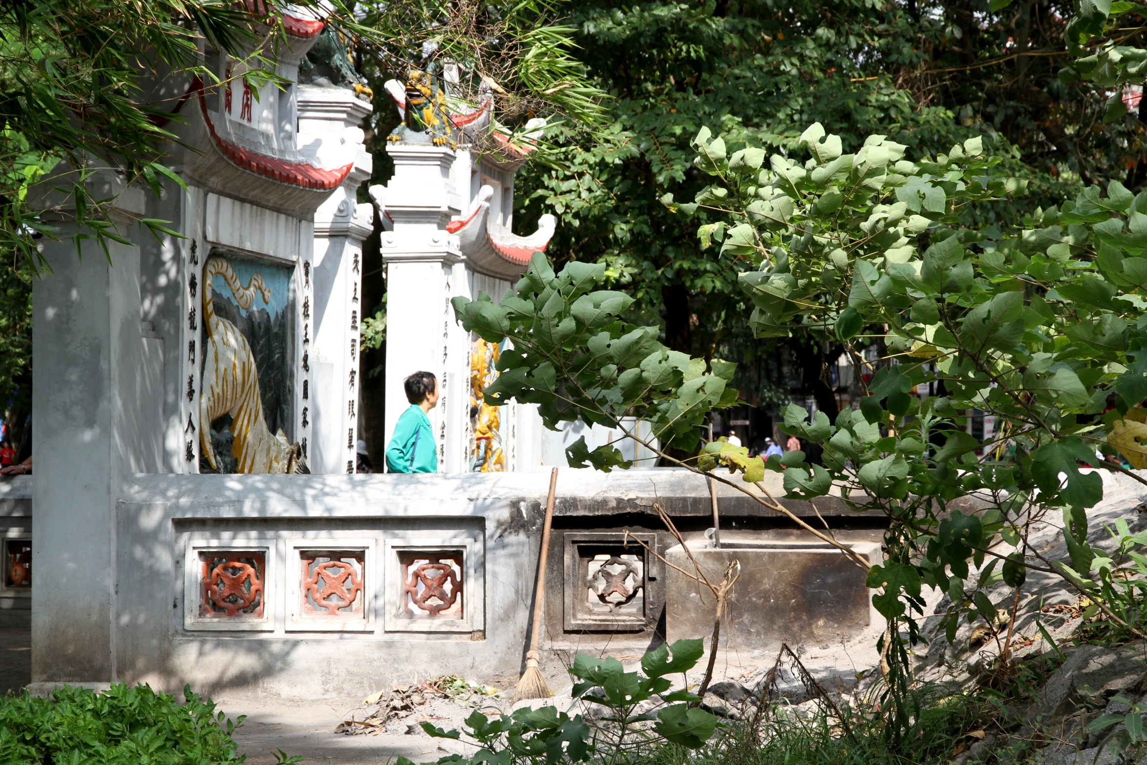 a little girl standing next to an old, carved up shrine