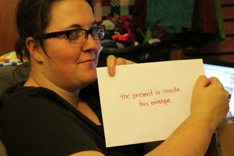 a woman is holding up a piece of paper with a message on it