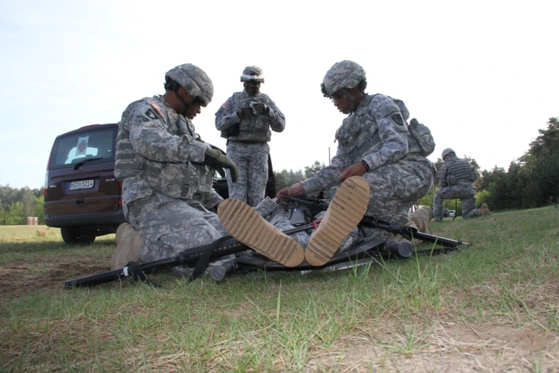soldiers using a wheeled army surface to treat for a injured person