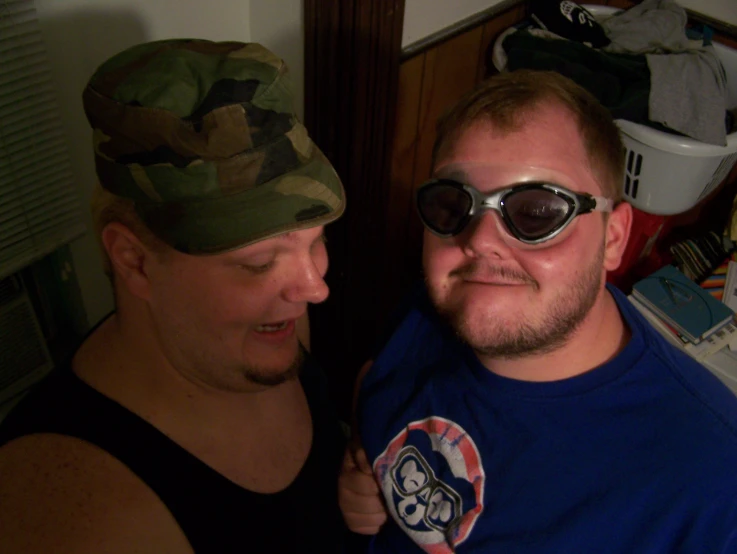 a man in a camo hat holding a man in a blue shirt